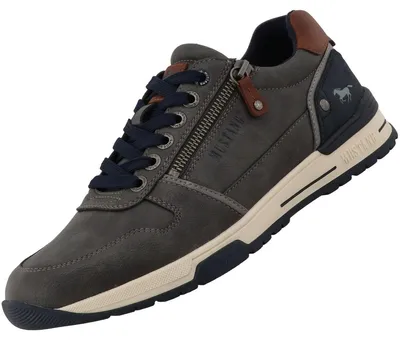 Auf dem Bild ist ein grauer Freizeitschuh zu sehen der aus einem glatten Material besteht. Der Schuh wird von der Außenseite gezeigt und hat eine weiße Sohle.