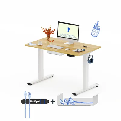 A white background with a light wood standing desk, computer, and accessories.