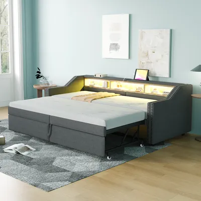A bedroom or living room setting with a sofa bed extended into a bed, featuring integrated lighting and storage.