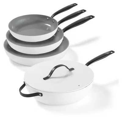 A set of white ceramic cookware with black handles, including stacked frying pans and a covered wok, arranged on a white background.