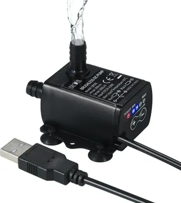 A black USB DC water pump with water flowing out of the nozzle, shown on a white background.