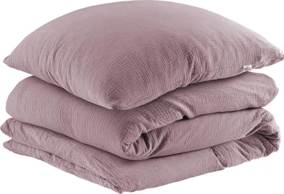 A stack of folded mauve-colored muslin bedding, including a pillow and a duvet cover, is shown against a white background.