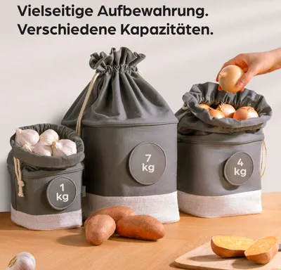 Three storage bags for vegetables, with a hand placing an onion into one of them. Sweet potatoes are in the foreground.