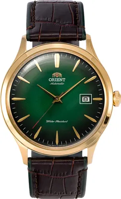 A close-up studio shot of a men's wristwatch with a green dial and gold accents, set against a white background.