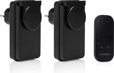 Two black smart plugs and a black remote control are displayed on a white background.