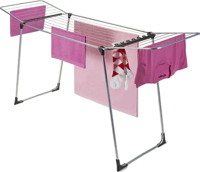 A metal drying rack with several pink towels and a pair of socks hanging on it, set against a white background.