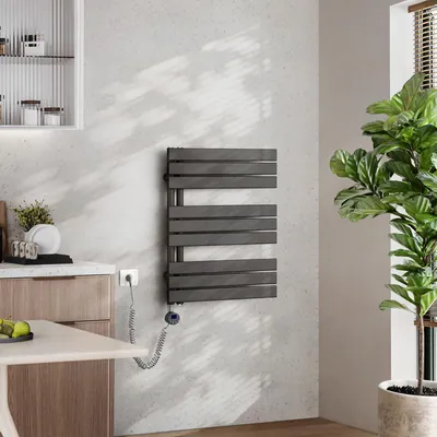 A modern bathroom or kitchen setting with a wall-mounted electric towel warmer.