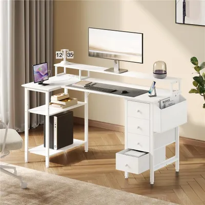 A white L-shaped computer desk with a monitor, keyboard, laptop, and storage drawers, set in a home office environment.