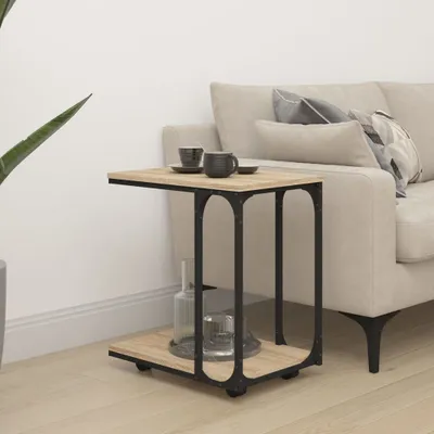 A C-table sits next to a sofa with two mugs on top and a bottle of water and a glass on the bottom shelf.