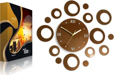 A modern wall clock with a circular face and surrounding rings, displayed next to its packaging.
