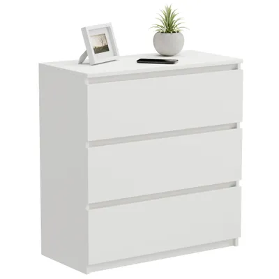 A white, three-drawer dresser with a framed picture and a potted plant on top.