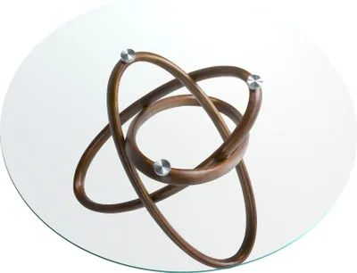 A close-up view of a round glass table with a wooden base.