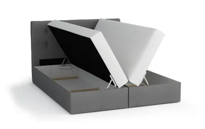 A bed frame with its mattress lifted to reveal storage space underneath.