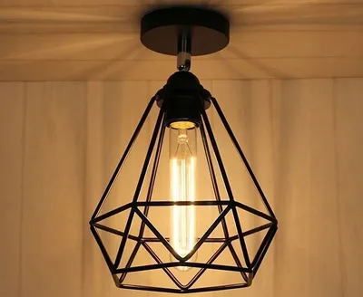 A close-up shot of a black geometric pendant light fixture with an exposed Edison bulb, mounted on a ceiling.