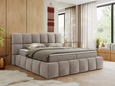 A bedroom scene with a large bed as the focal point, decorated with soft furnishings and natural light from a window.