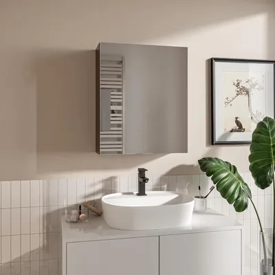 A modern bathroom vanity with a sink, faucet, and a mirror cabinet.