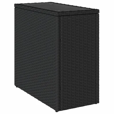 A black rattan side table with a glass top, shown from a three-quarter angle against a white background.