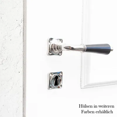A close-up view of a door handle and keyhole on a white door.