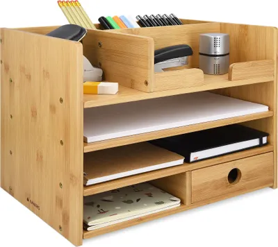 A bamboo desk organizer filled with office supplies.