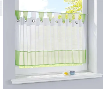 A sheer curtain with a green border hangs in a window.