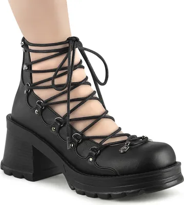A close-up shot of a black lace-up boot on a person's foot.