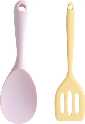 Two kitchen utensils, a pink spoon and a yellow slotted spatula, are shown side-by-side against a white background.