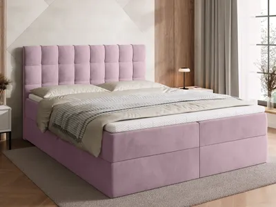 A pink boxspring bed with a tufted headboard is shown in a bedroom setting.