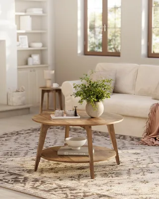 A wooden coffee table with a two-tiered design, placed on a patterned rug in a living room setting.