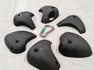 Klettergriffe Essentials Set 2 von Greenholds; bestehend aus sechs schwarzen L-Klettergriffen und einem Karabiner.