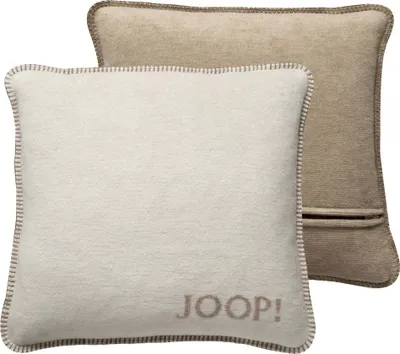 Two pillows are shown, one in front of the other. The front pillow is cream colored with the brand name 'JOOP!' embroidered on it. The back pillow is beige and shows a zipper.