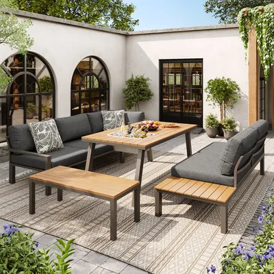 An outdoor patio setting with a lounge set, dining table, and coffee table.