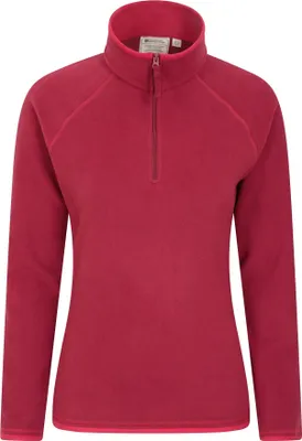 A plain white background with a women's fleece top.