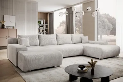 A modern living room with a large sectional sofa, coffee table, and large window.