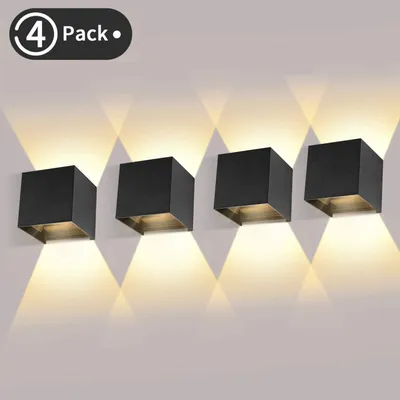 Four modern black cube-shaped wall lights mounted on a white wall, casting upward and downward light.