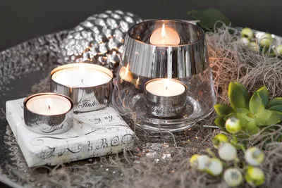 A decorative arrangement of lit tea lights and festive elements.