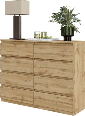 A wooden dresser with eight drawers is shown against a white background, with a lamp and decorative items on top.