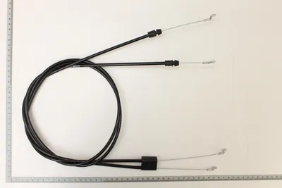 A set of two black Bowden cables with silver metal ends, laid out on a white background with a ruler along the bottom edge.