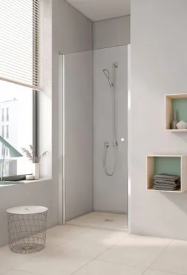 A modern bathroom with a shower enclosure, window, and shelves.