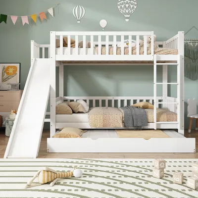 A white bunk bed with a slide and a pull-out trundle bed, set in a child's bedroom with decorative hot air balloons and a banner.