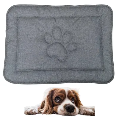 A gray dog mat with a paw print design is shown above a dog lying down.