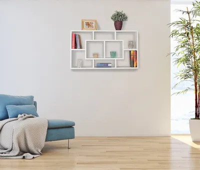 A modern living room with a blue sofa and a white wall-mounted shelf unit.