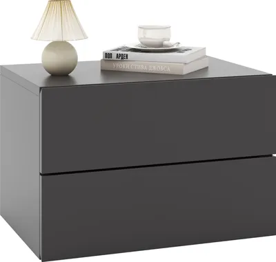 A modern, dark gray nightstand with two drawers, a lamp, and books on top, presented on a white background.