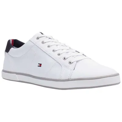 A white Tommy Hilfiger sneaker is shown from a side angle against a white background.
