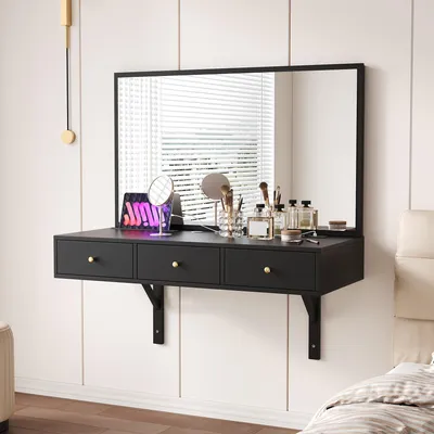 A black floating vanity desk with a large mirror mounted on a white wall, decorated with makeup and accessories.