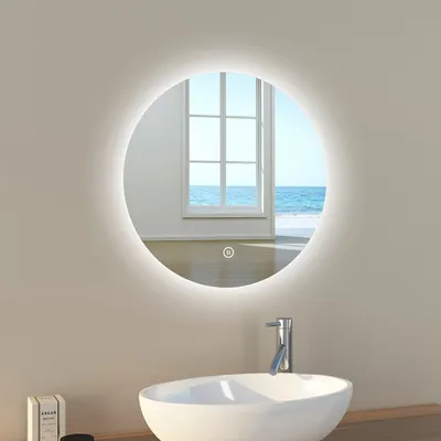 A round LED mirror with a light ring is mounted on a wall above a sink in a bathroom.