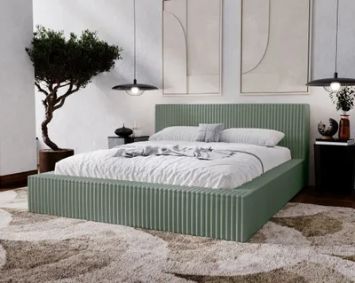 A bedroom scene with a green upholstered bed as the focal point.