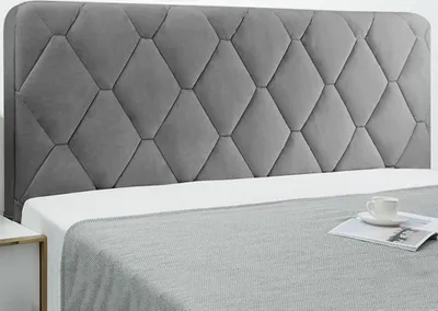 A close-up of a grey diamond-tufted headboard.