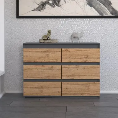 A modern dresser with six drawers against a textured wall.