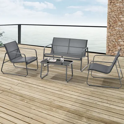 A patio furniture set on a wooden deck overlooking the water.