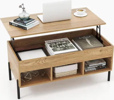 A wooden coffee table with its top lifted, revealing storage compartments. A laptop, books, and a vase are on the table.